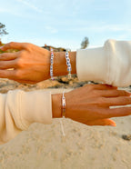 Elevated Faith Christian Jewelry Bracelet displayed on wrists near beach at sunset