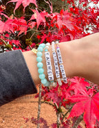 Elevated Faith Christian Jewelry Bracelet with colorful beads and inspiring letters on a wrist among autumn leaves