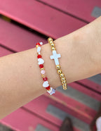 Elevated Faith Christian Jewelry Bracelet with gold beads and a cross design on a wrist