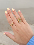 Gold Christian Jewelry Rings Stacked on Hand with Cross and Sun Design for Faith-Inspired Fashion