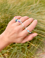 Colorful elevated faith rings stacked on a hand showcasing stylish Christian jewelry designs
