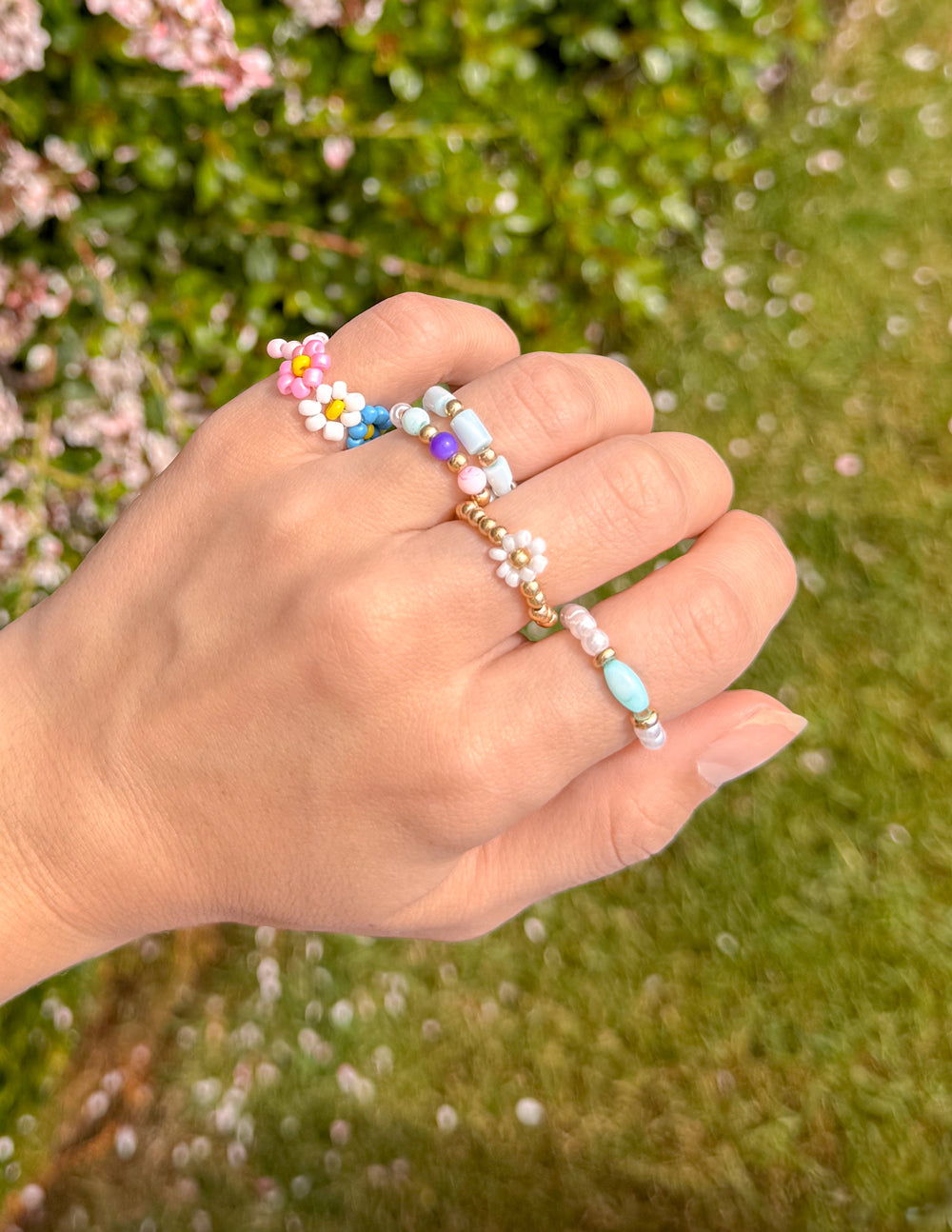 Colorful Elevated Faith Rings stacked on a hand, showcasing vibrant Christian Jewelry design