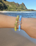 Elevated Faith Christian Jewelry Bracelet featuring stone beads and cross charms on a beach backdrop