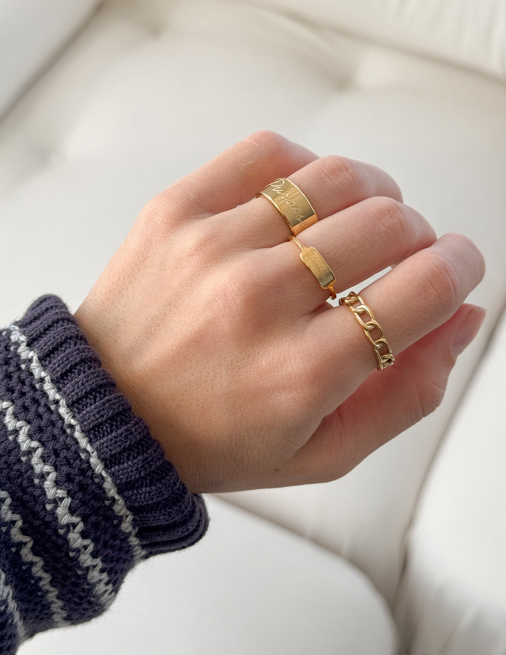 Two gold rings on a hand, ideal for expressing faith as Christian Jewelry from Elevated Faith