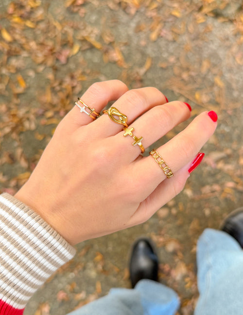 Collection of Elevated Faith Christian Jewelry Rings on a Hand with Autumn Leaves Background