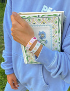 Elevated Faith Christian Jewelry Bracelet worn on wrist while holding a decorative book