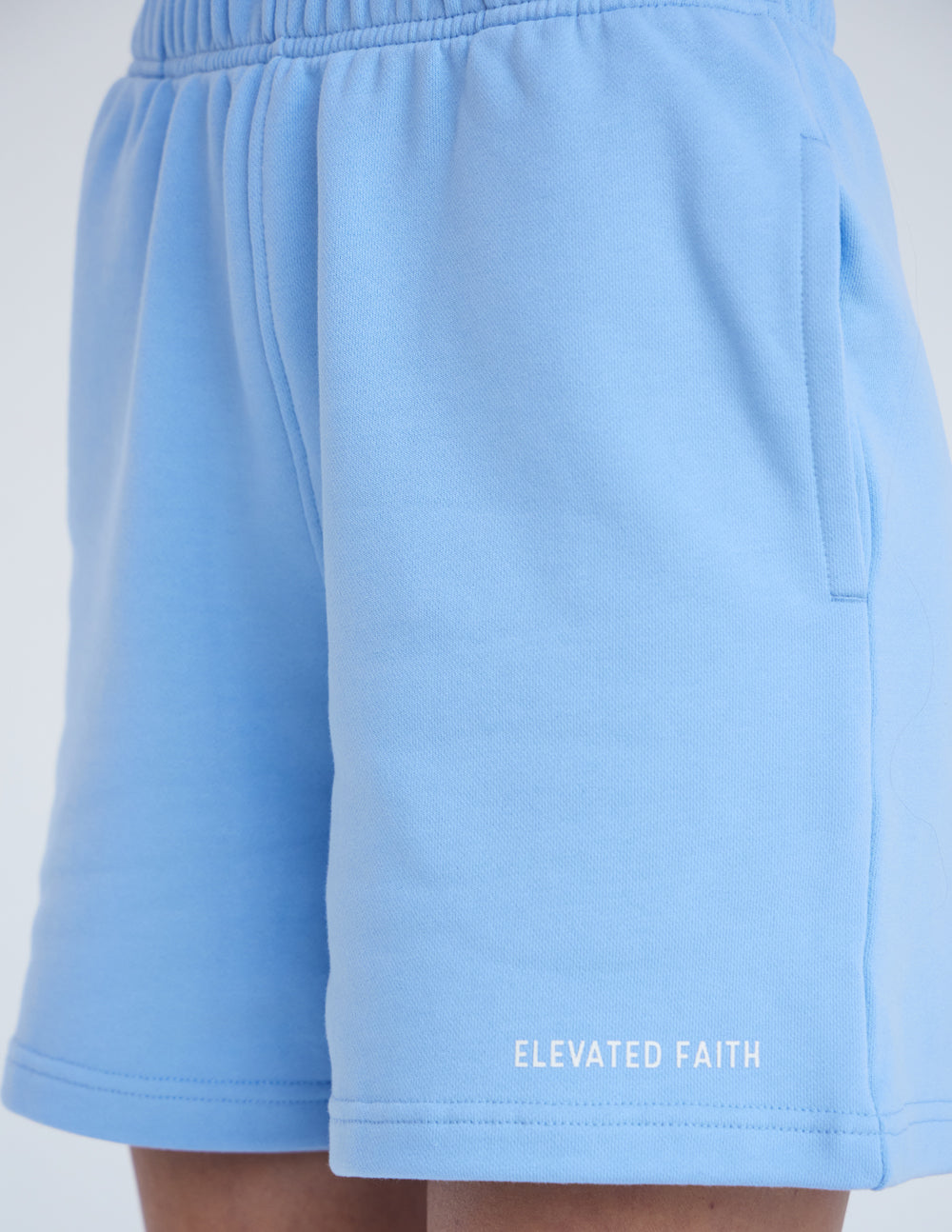 Light blue Elevated Faith shorts featuring side pockets, perfect for everyday casual wear with a Christian theme.