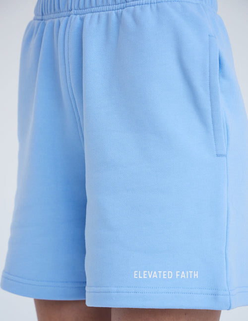 Light blue Elevated Faith shorts featuring side pockets, perfect for everyday casual wear with a Christian theme.