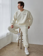 Elevated Faith Christian Crewneck Sweatshirt in cream color, modeled by a man sitting on a stool