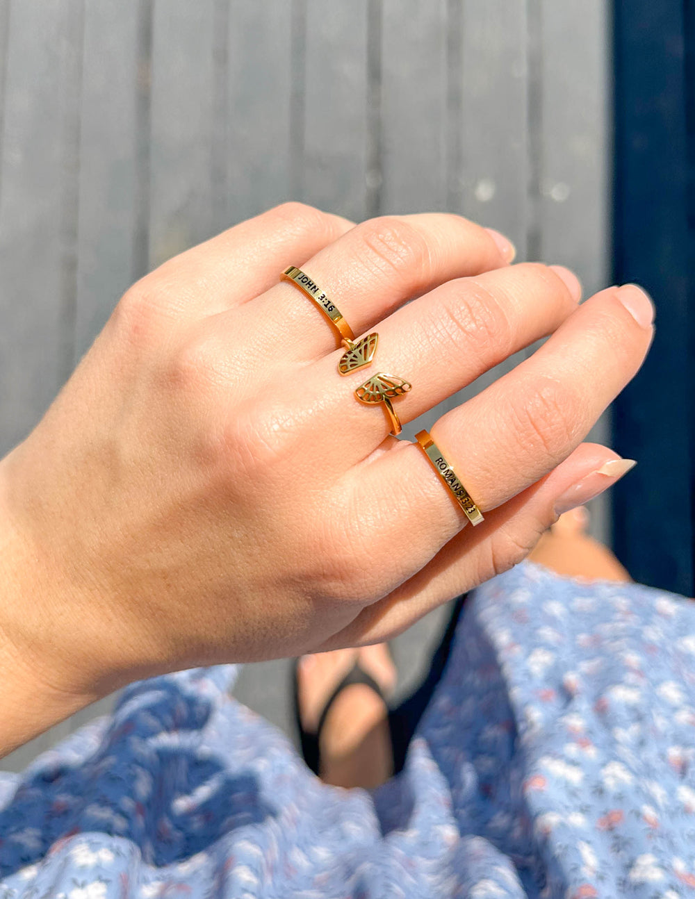 Elevated Faith Christian Jewelry featuring elegant rings stacked on a hand outdoors