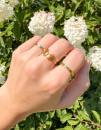Elegant gold ring set by Elevated Faith showcasing Christian jewelry designs on a hand with flowers
