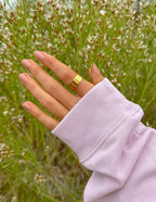 Elevated Faith Gold Ring on Hand amid Delicate Flowers, Perfect Christian Jewelry for Everyday Wear
