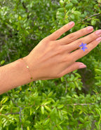 Elevated Faith Christian Jewelry Bracelet in gold with charming heart charms on a hand against foliage