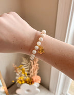 Elevated Faith Christian Jewelry Bracelet featuring white stones and a gold dove charm on a wrist