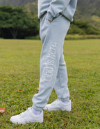 Light blue sweatpants from Elevated Faith featuring 'God is here' text, ideal for Christian Apparel
