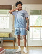 Man wearing Elevated Faith Christian Shorts with matching ombre t-shirt in a bright living room setting