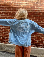 Elevated Faith Christian Jacket with embroidered 'God of Miracles' on the back in faded denim