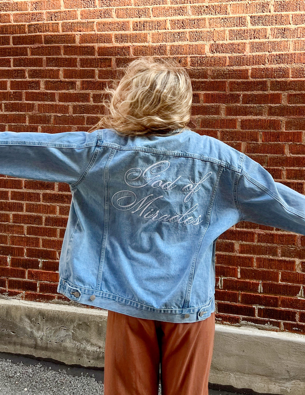 Elevated Faith Christian Jacket with embroidered 'God of Miracles' on the back in faded denim