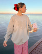 Woman wearing a beige Christian Crewneck Sweatshirt by Elevated Faith with heart design by the water