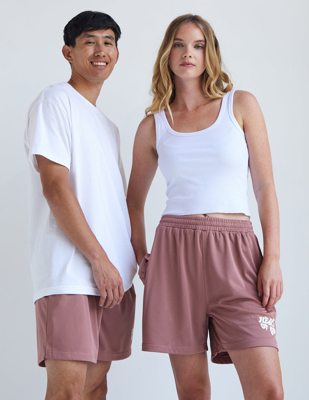 Couple wearing Elevated Faith Christian Shorts in light pink with breathable fabric for comfort and style