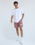 Male model wearing pink Christian Shorts from Elevated Faith with a white t-shirt and sneakers