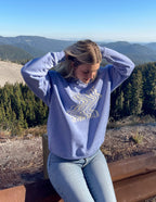 Elevated Faith Christian Crewneck Sweatshirt in light purple worn outdoors with scenic mountain backdrop