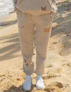 Elevated Faith beige sweatpants featuring butterfly designs, perfect for Christian Apparel enthusiasts