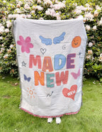 Colorful blanket from Elevated Faith featuring 'Made New' design, perfect as Christian gifts
