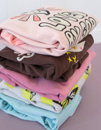 Stack of colorful Christian Crewneck Sweatshirts in various designs and colors folded neatly