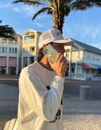 Young man using a Christian iPhone Case featuring vibrant graphics at a sunny outdoor location