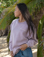 Woman wearing a lavender Christian Crewneck Sweatshirt with the text Peace of God in a natural setting