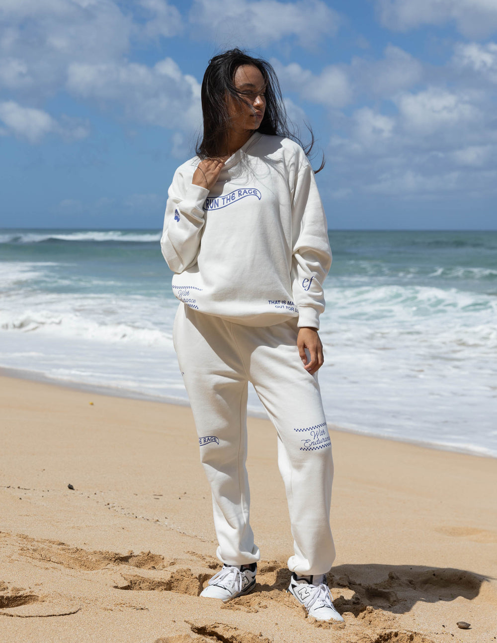 Elevated Faith Christian Crewneck Sweatshirt in light color, worn on a beach with waves in the background