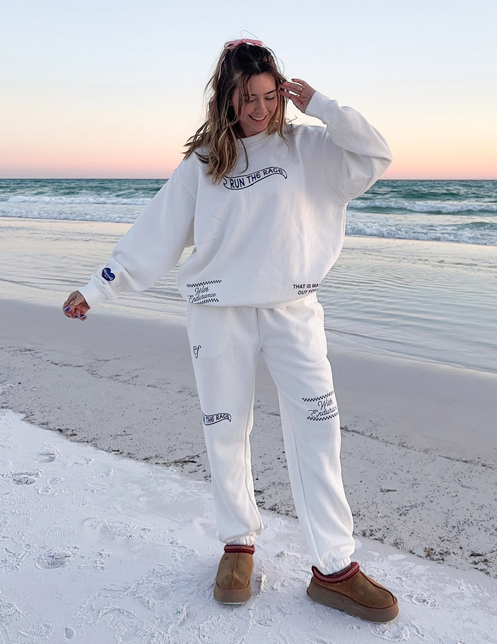 Women in white Christian Crewneck Sweatshirt on the beach with sandy shoreline and ocean waves
