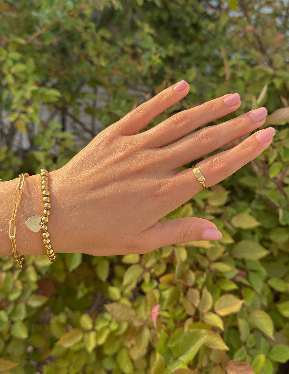 Elevated Faith Christian Jewelry Gold Ring Worn on Hand among Greenery and Accessories