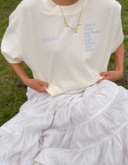 Elevated Faith Christian Jewelry necklace worn with a cream oversized t-shirt and layered white skirt