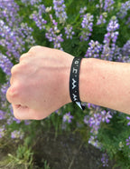 Elevated Faith Christian Jewelry Bracelet on wrist with purple flowers background for a stylish look