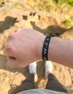 Elevated Faith Christian Jewelry Bracelet in black with inspirational text worn on wrist outdoors