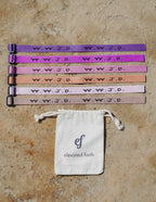 Set of colorful Elevated Faith Christian Jewelry Bracelets displayed with a storage pouch