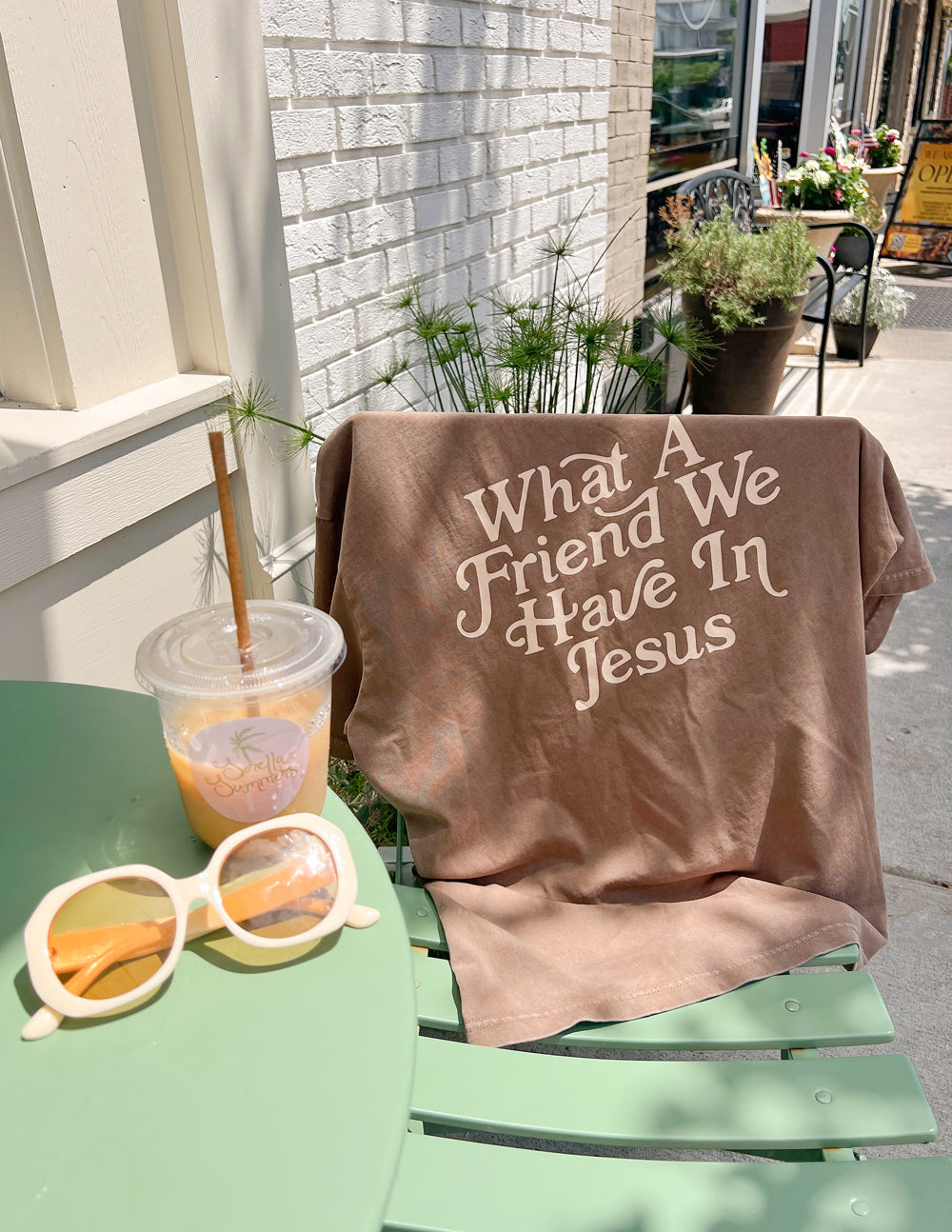 Elevated Faith Christian Apparel T-Shirt featuring 'What A Friend We Have In Jesus' design on a patio table