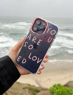 Elevated Faith Christian iPhone Case featuring 'You Are So Loved' design on a scenic beach background