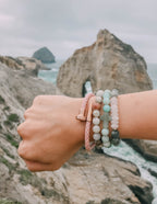 Elevated Faith Christian Jewelry Bracelet with stone beads worn on a scenic coastal background