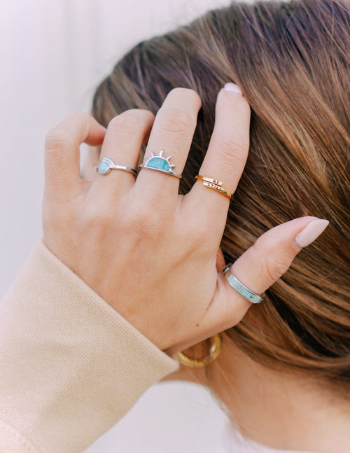 Elevated Faith Christian Jewelry rings displayed on a hand with a stylish design and various colors