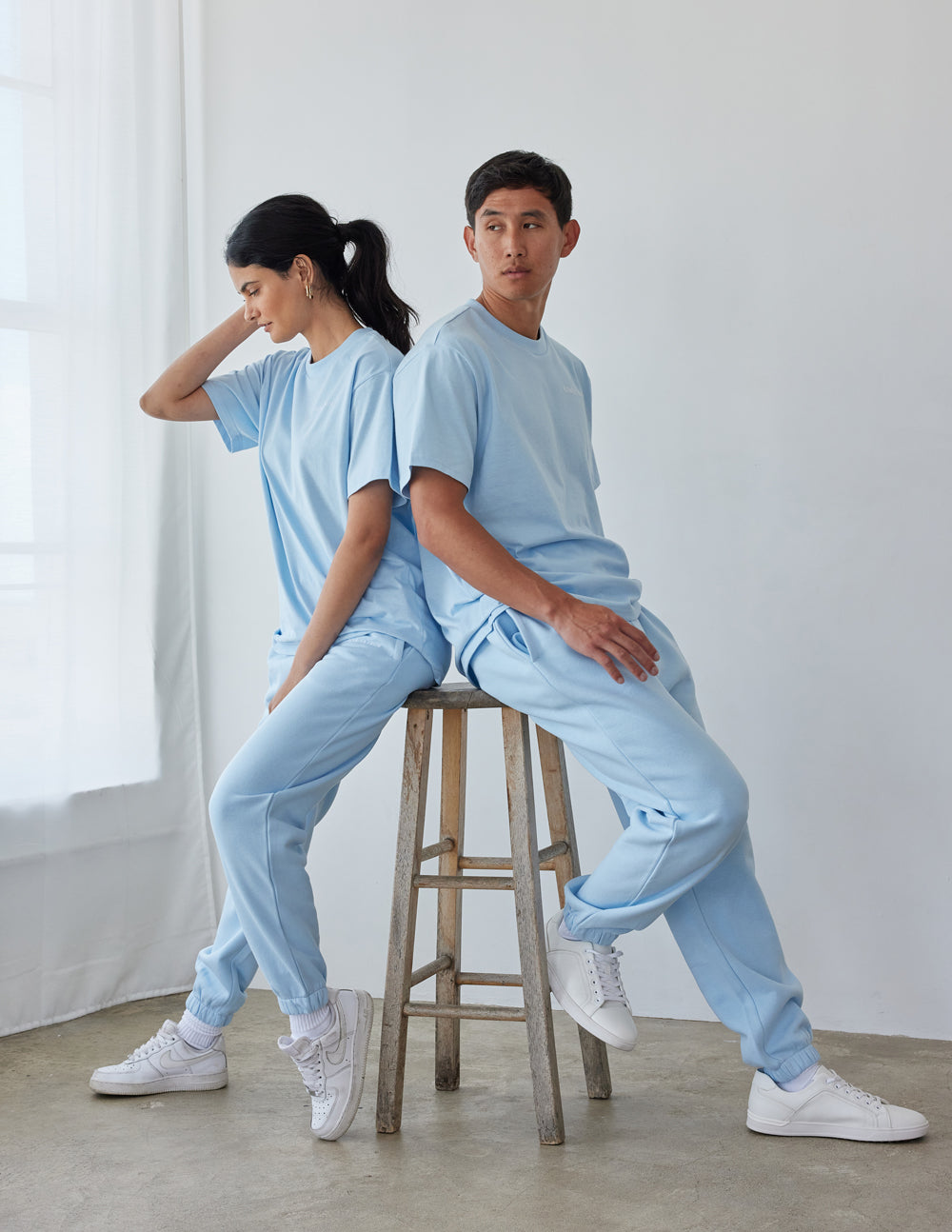 Elevated Faith Christian Apparel T-Shirt in light blue worn by male and female models seated on a stool