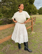 Woman wearing Elevated Faith Christian Apparel T-Shirt with a white skirt and black boots outdoors