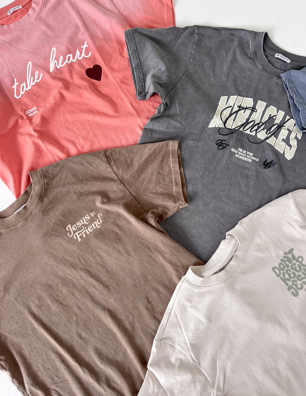 Variety of Elevated Faith Christian Apparel T-Shirts in different colors and designs for inspirational fashion