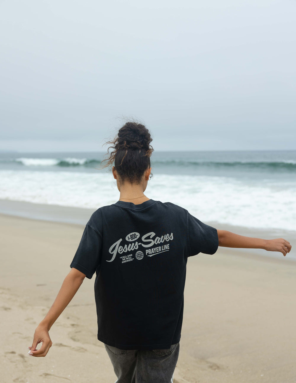 Elevated Faith Christian Apparel T-Shirt in black with Jesus Saves graphic on a beach