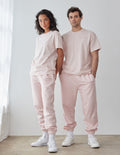 Couple wearing light pink Elevated Faith Christian Apparel T-Shirt with matching sweatpants in a bright space
