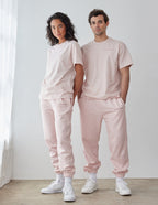 Couple wearing light pink Elevated Faith Christian Apparel T-Shirt with matching sweatpants in a bright space