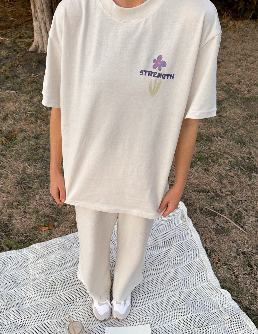 Cream Elevated Faith Christian Apparel T-Shirt featuring a floral design and the word Strength