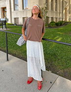 Chic woman wearing a brown Elevated Faith T-Shirt paired with a white skirt, showcasing Christian Apparel T-Shirt style